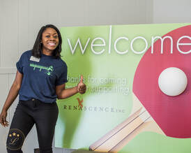 Image of volunteer with Ping Pong Tournament welcome sign